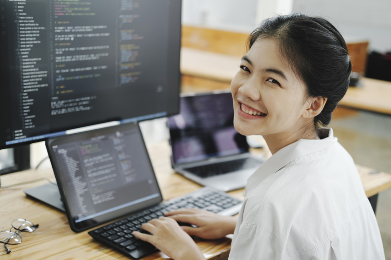 Young programmer working on desktop PC in office of software com
