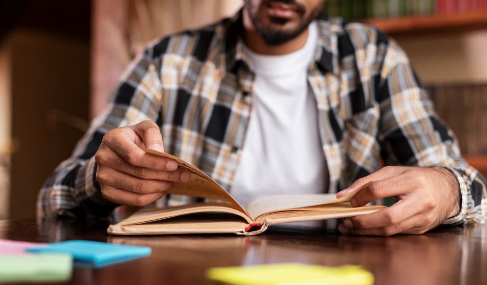 student-guy-reading-book-learning-sitting-in-libra-2025-03-18-17-23-26-utc