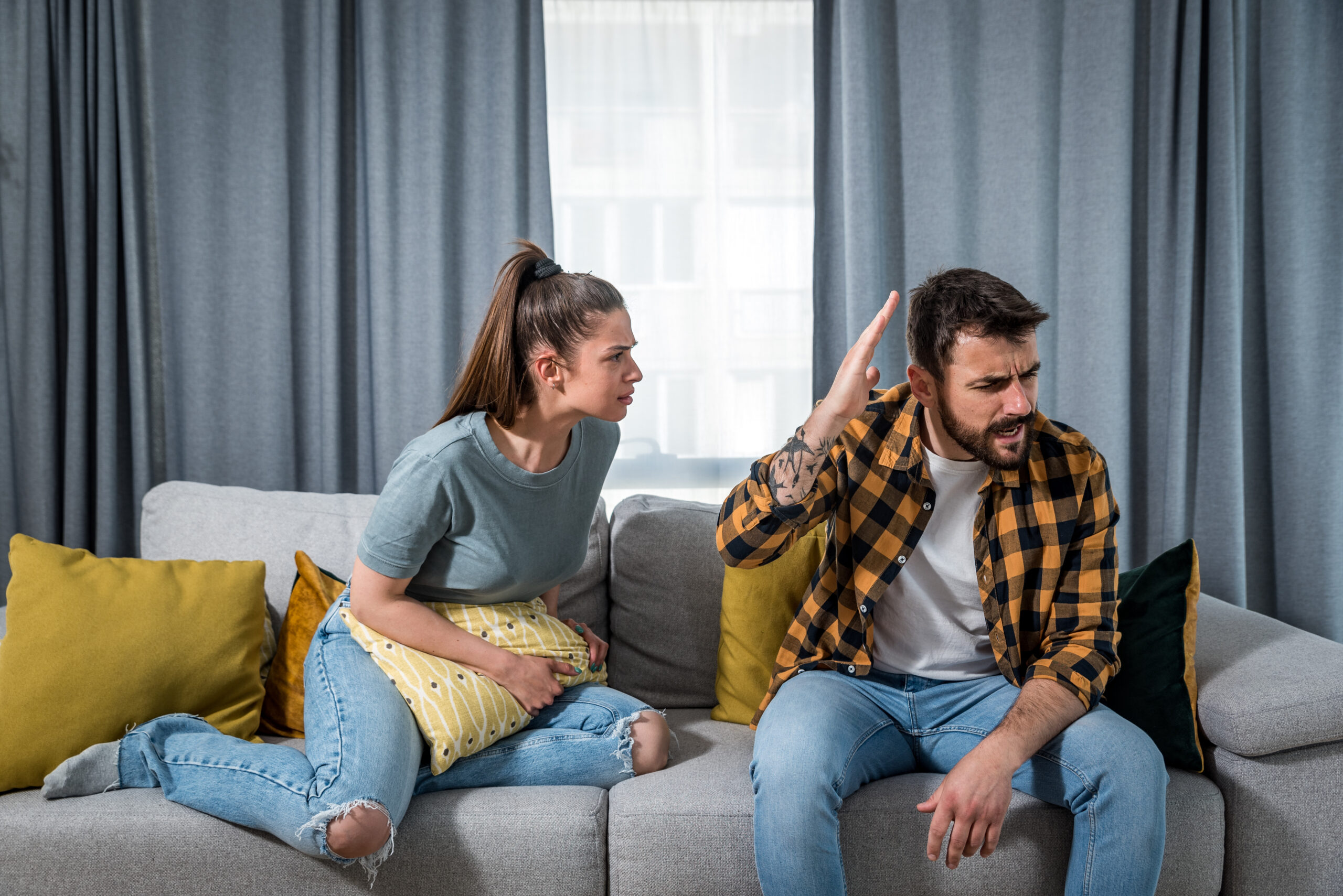 Young,Couple,Woman,And,Man,Sitting,On,The,Sofa,In